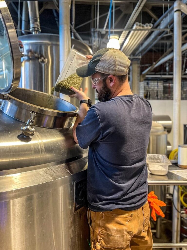 A hand holding a can of IPA beer.